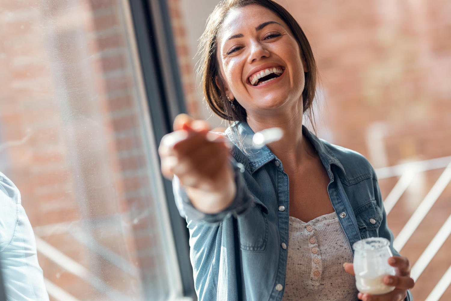 Ragazza offre alla camera un cucchiaio con la colazione