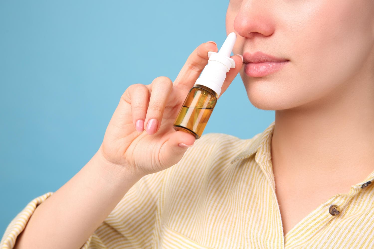 Donna che usa uno spray nasale