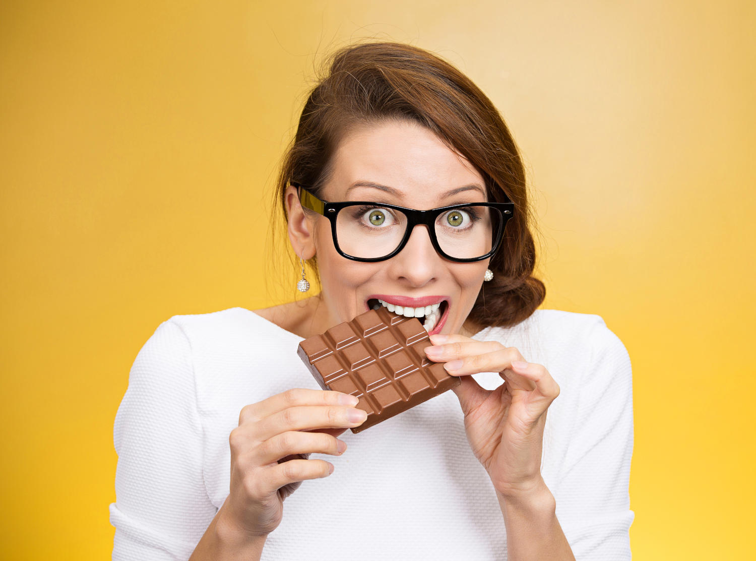 Ragazza che morde una tavoletta di cioccolato