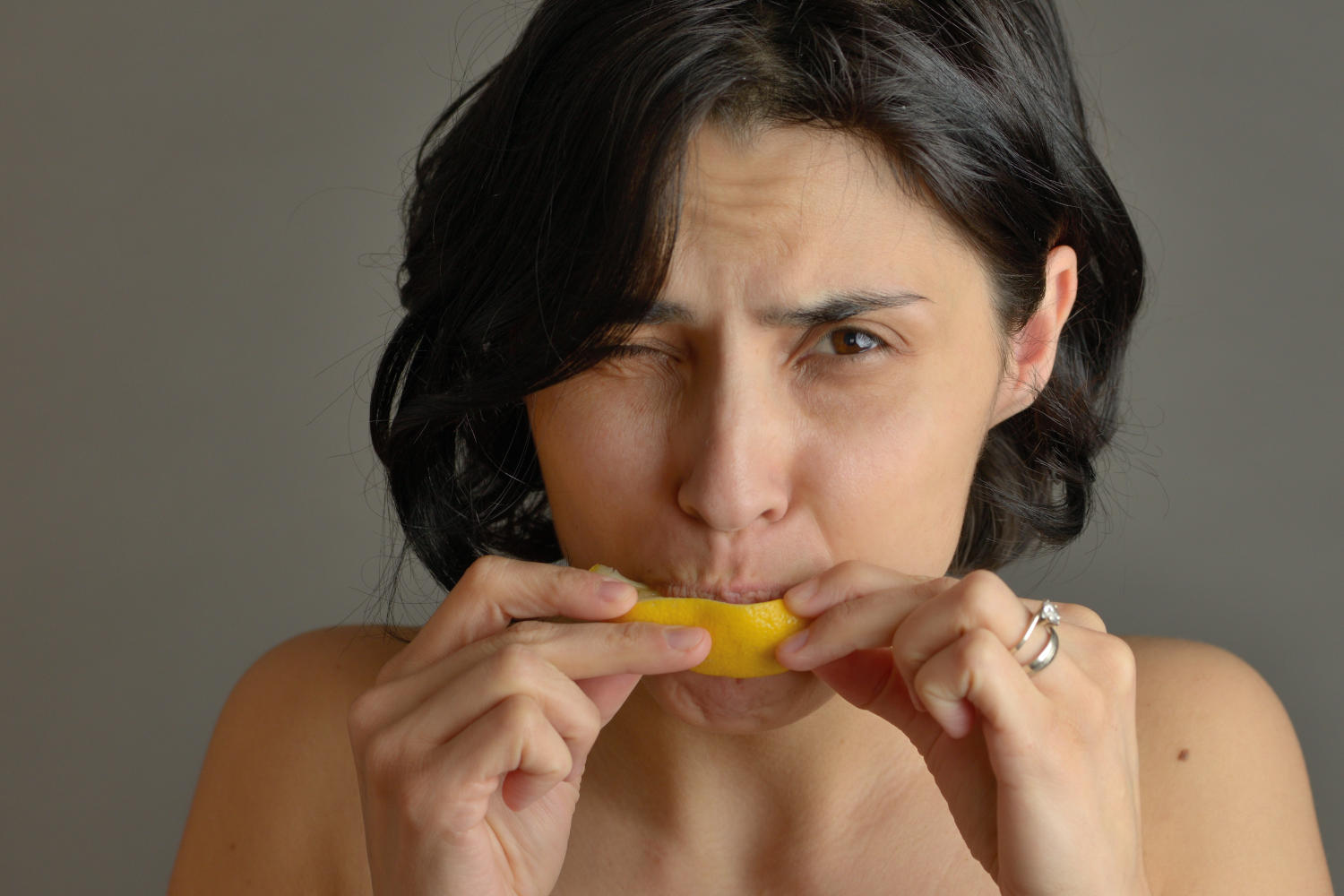 Ragazza morde una fetta di limone