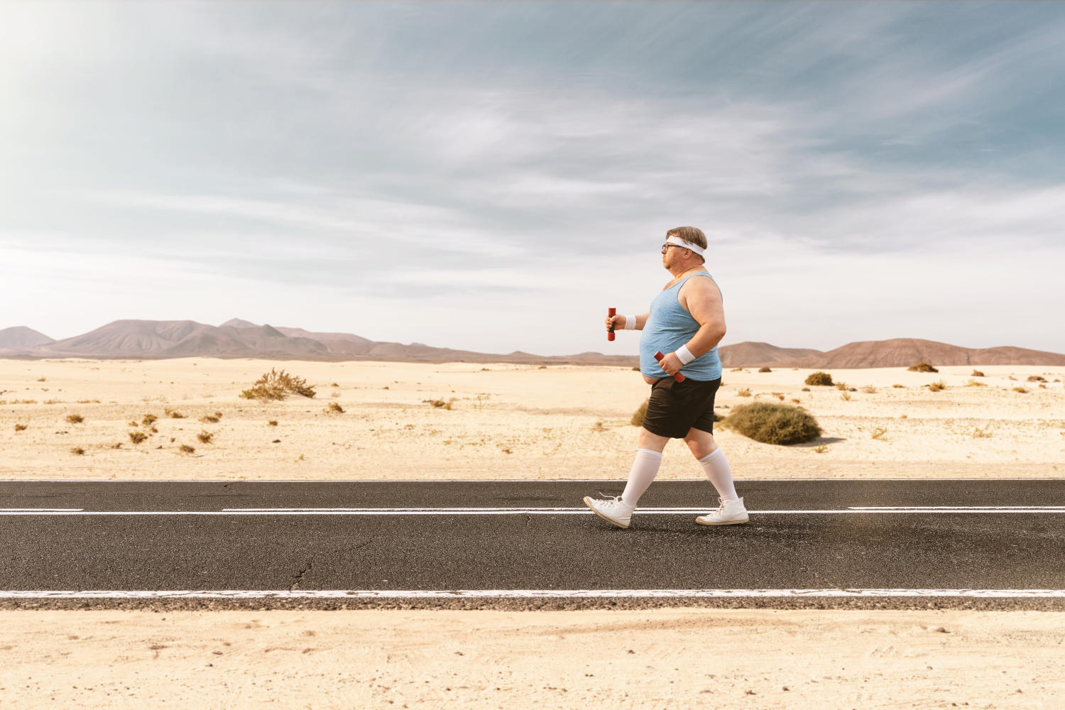 Uomo sovrappeso che cammina nel deserto
