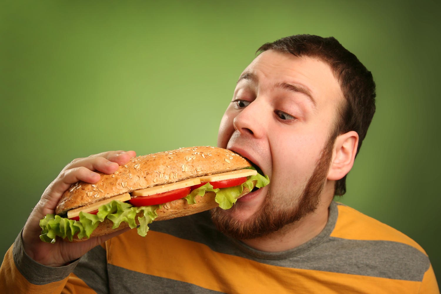 Ragazzo che mangia un panino enorme
