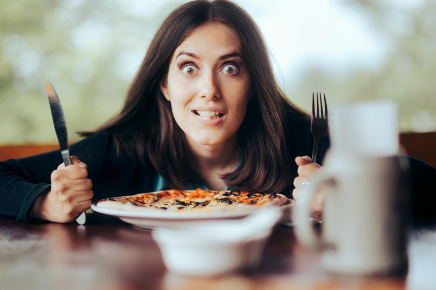 Donna affamata di fronte a una pizza