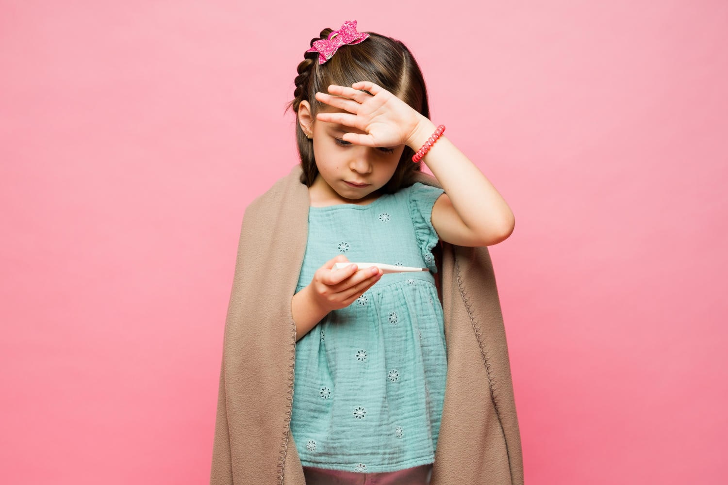 Bambina che si misura la febbre