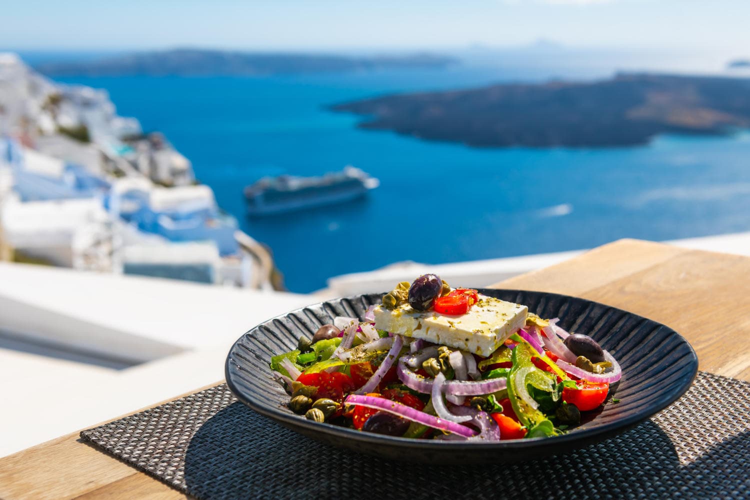Insalata greca, simbolo di dieta mediterranea, con il mare sullo sfondo