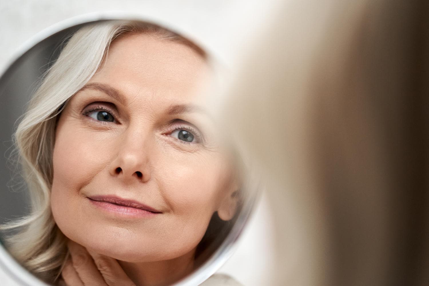 Donna in menopausa allo specchio che sorride