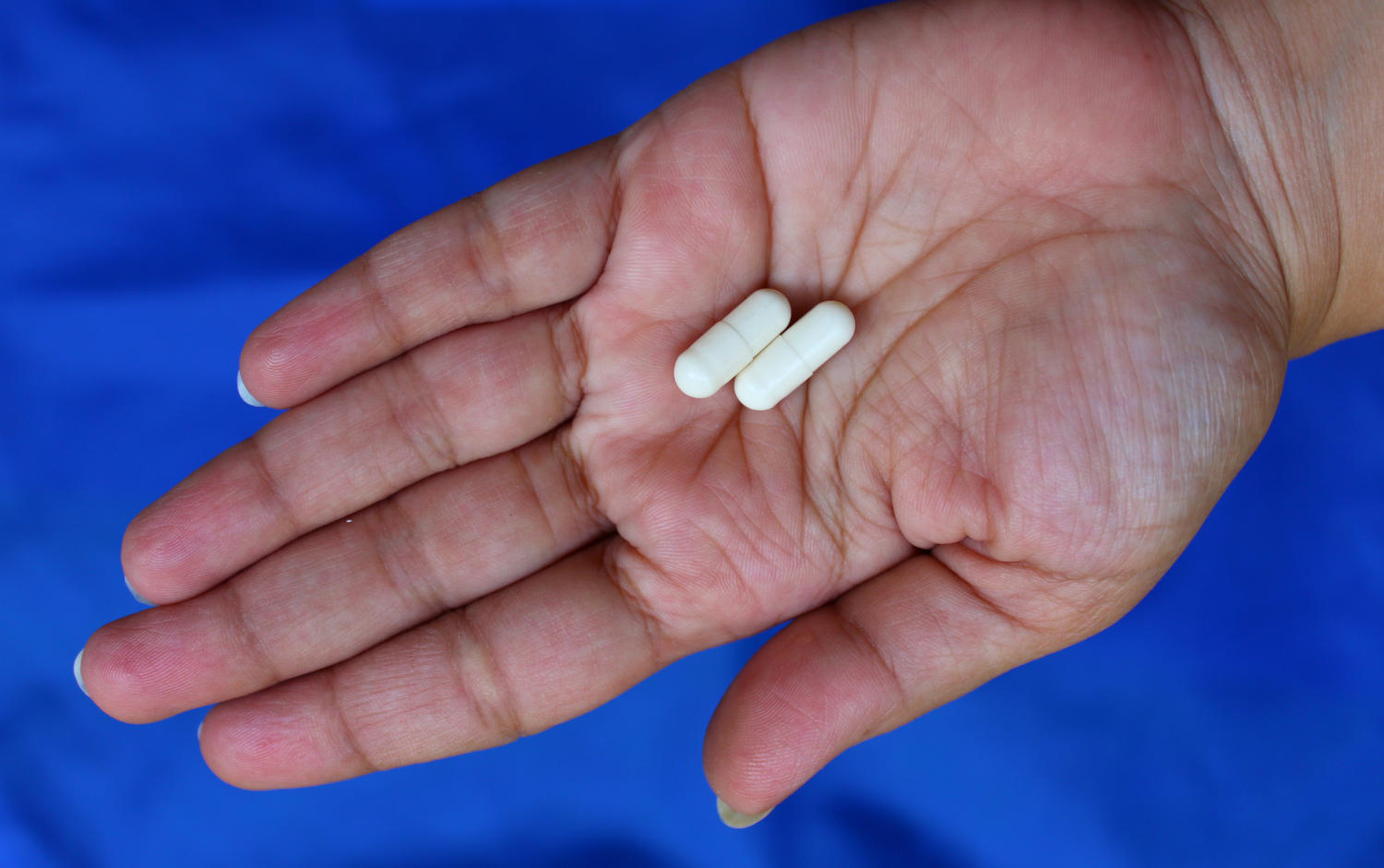 2 capsule di chitosano nella mano di una donna