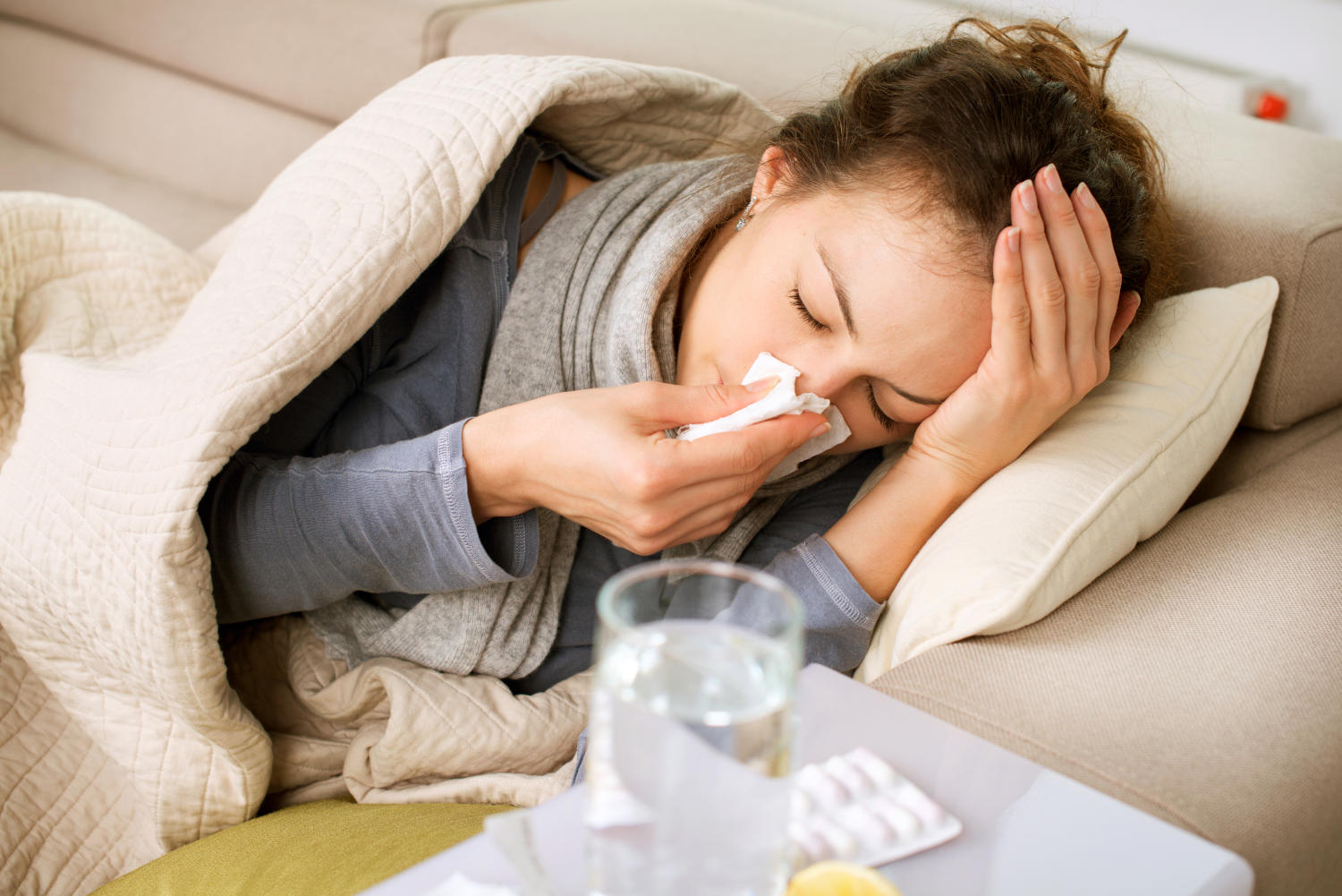 Ragazza sul divano con l'influenza