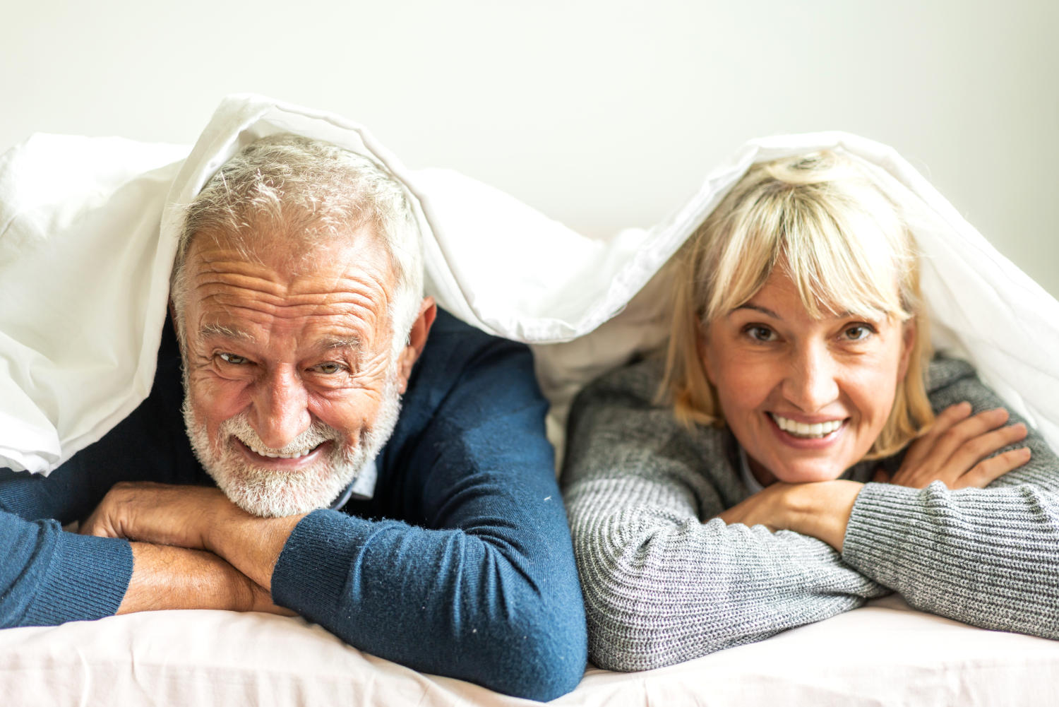 Coppia matura sul letto che sorride