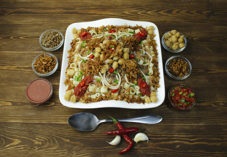 Un piatto di koshari affiancato da alcuni dei suoi ingredienti