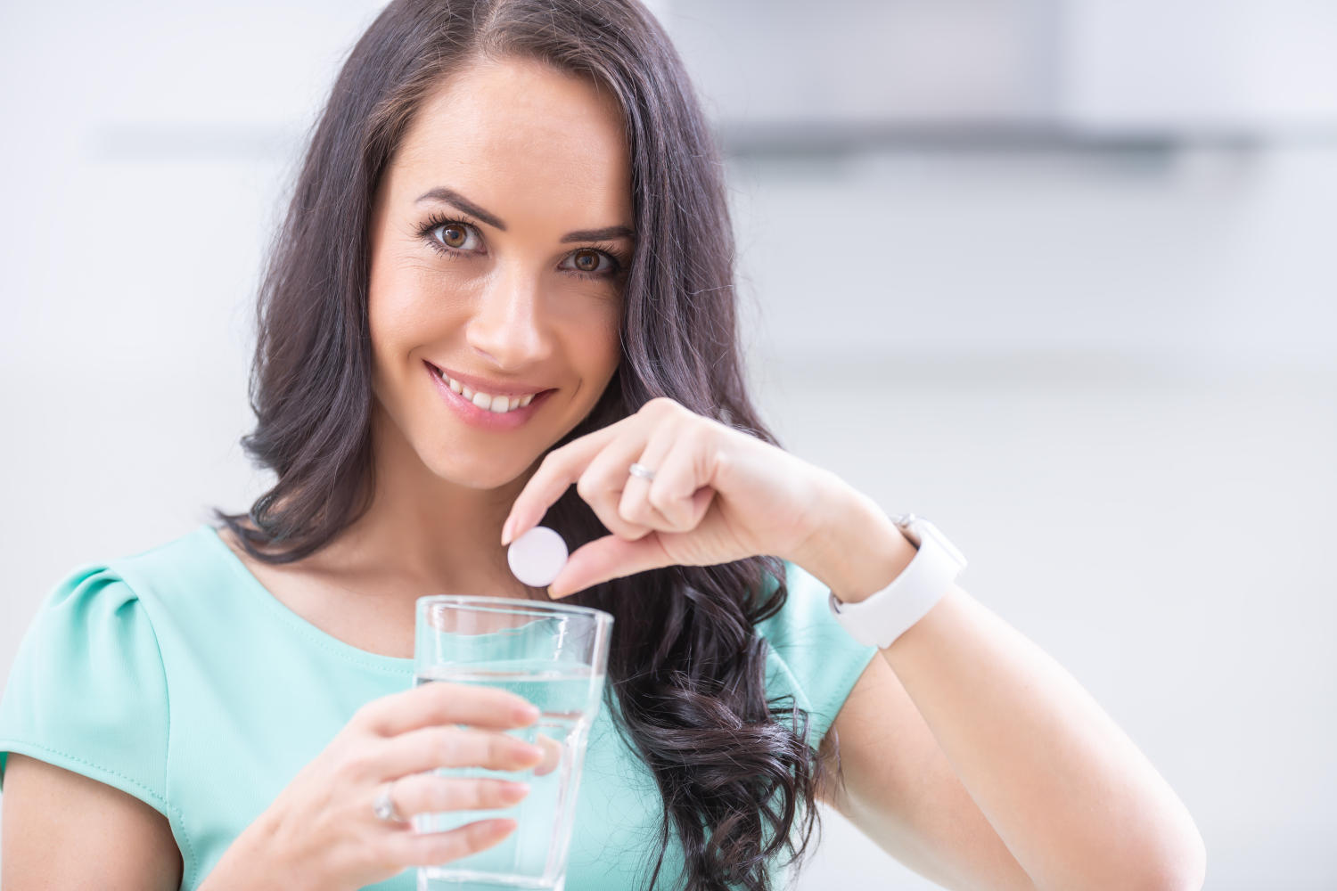 Ragazza con una pastiglia effervescente in mano