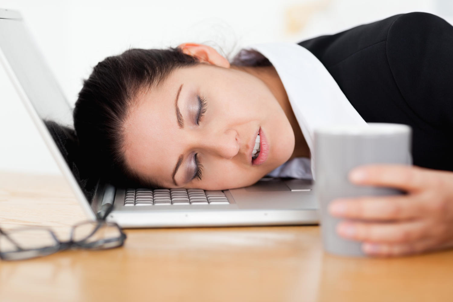 Donna che dorme con la testa sulla tastiera del portatile