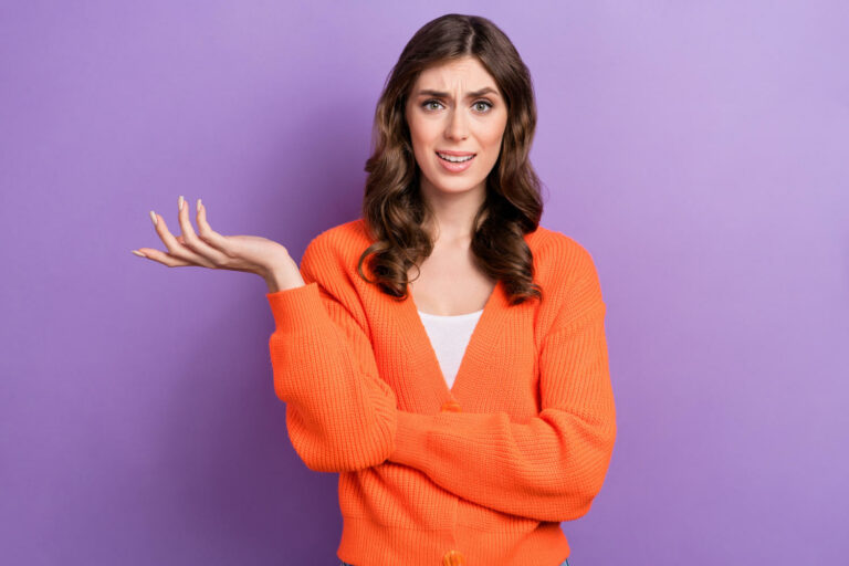 Ragazza con maglia di colore arancione che si chiede perchè