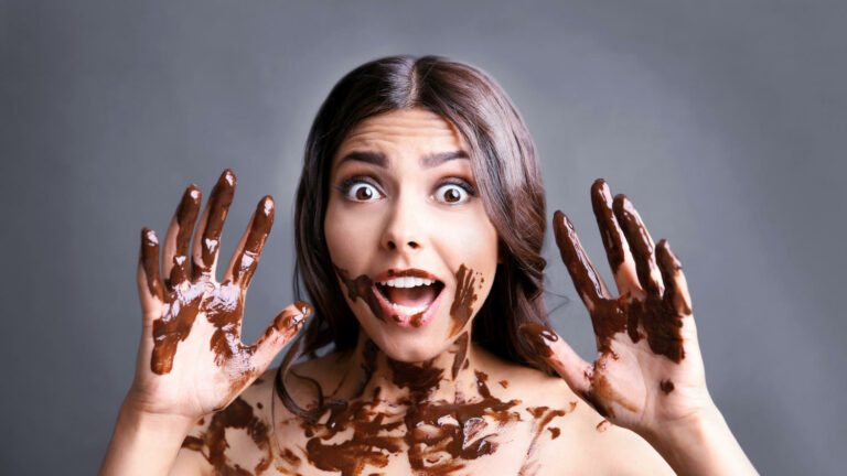 Ragazza che mangia del cioccolato ed è tutta sporca