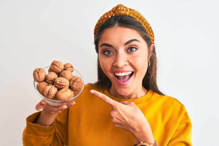 Ragazza che indica una ciotola di noci