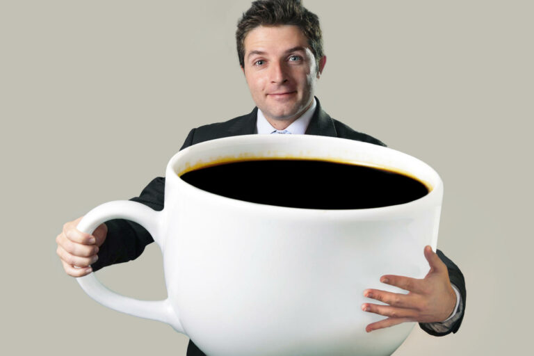 Uomo con in mano una tazzina di caff&egrave; gigante