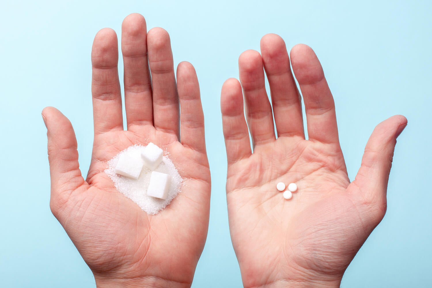 Mano sinistra che presenta dello zucchero, quella destra dell'aspartame