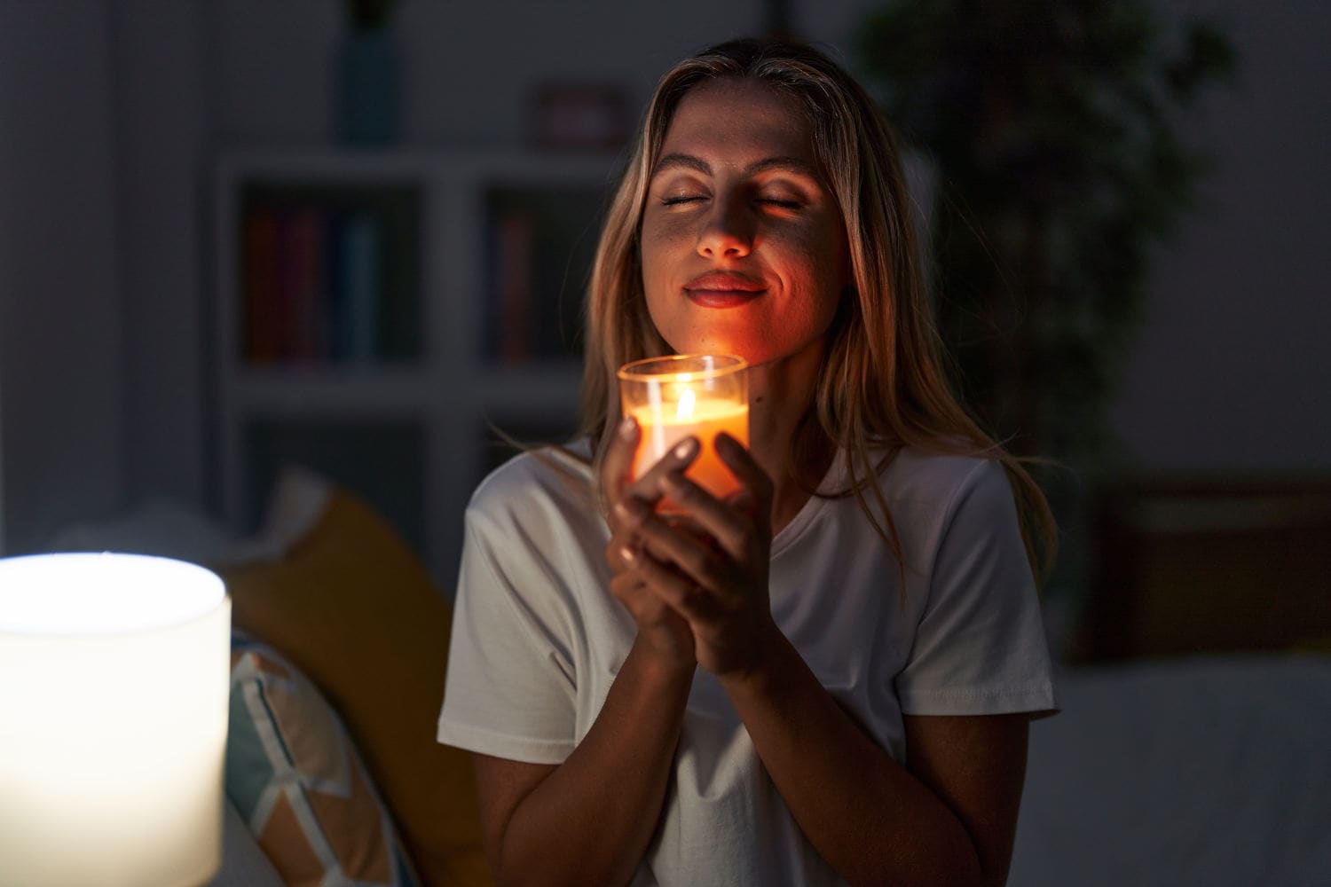 Ragazza con una candela in mano in una stanza buia
