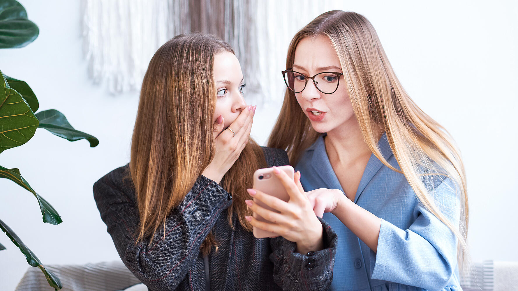 Due amiche guardano un po' sconvolte il cellulare