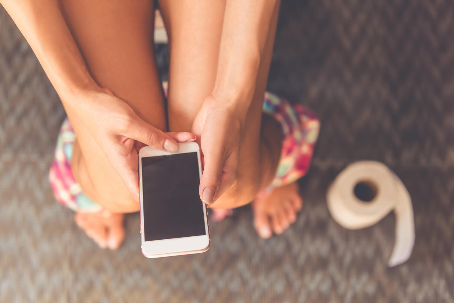 Ragazza che usa il cellulare in bagno
