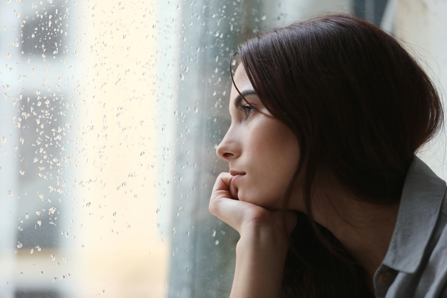 Ragazza pensierosa di fronte alla finestra