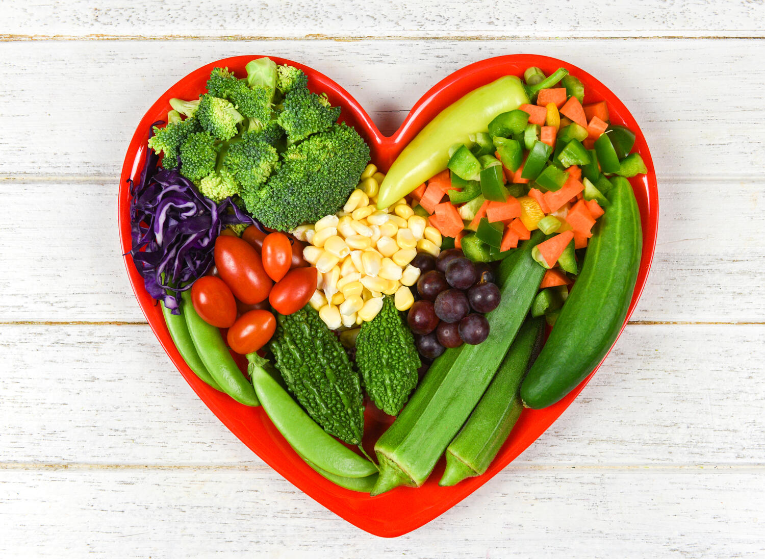 Piatto a forma di cuore ricco di alimenti vegetali
