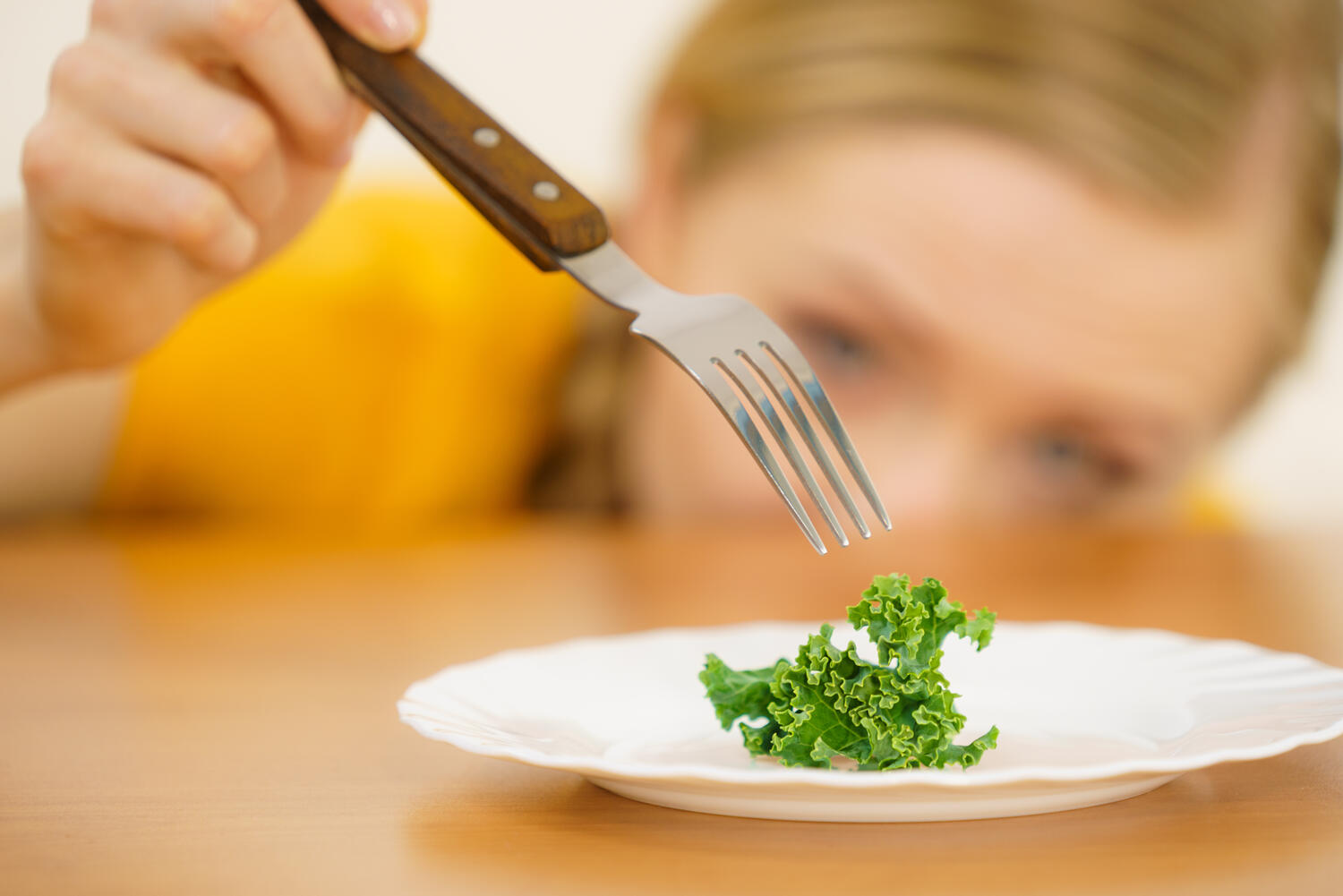 Ragazza frustrata di fronte a una fogliolina di insalata