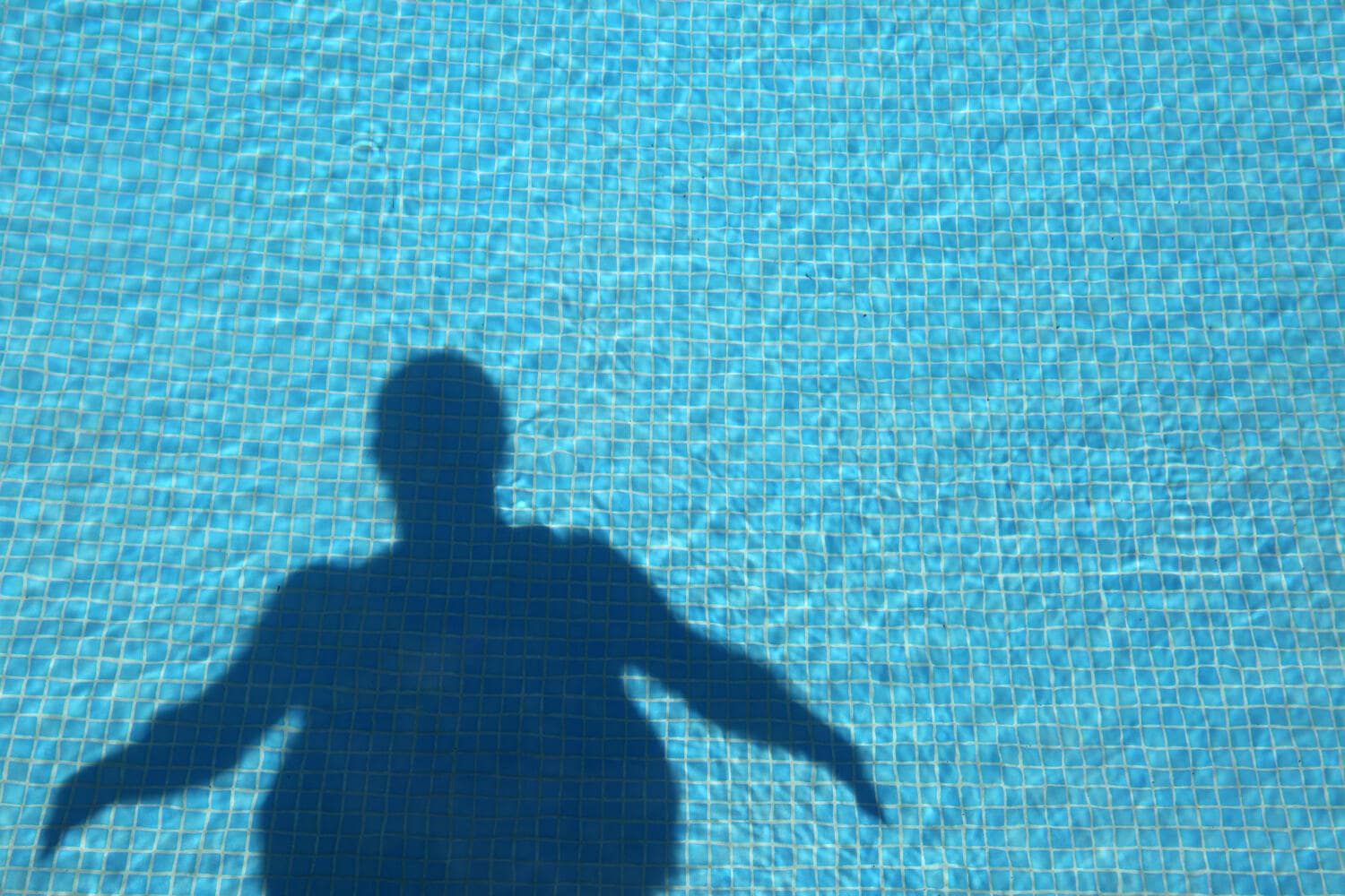 Ombra di un nuotatore in sovrappeso proiettata sulla piscina