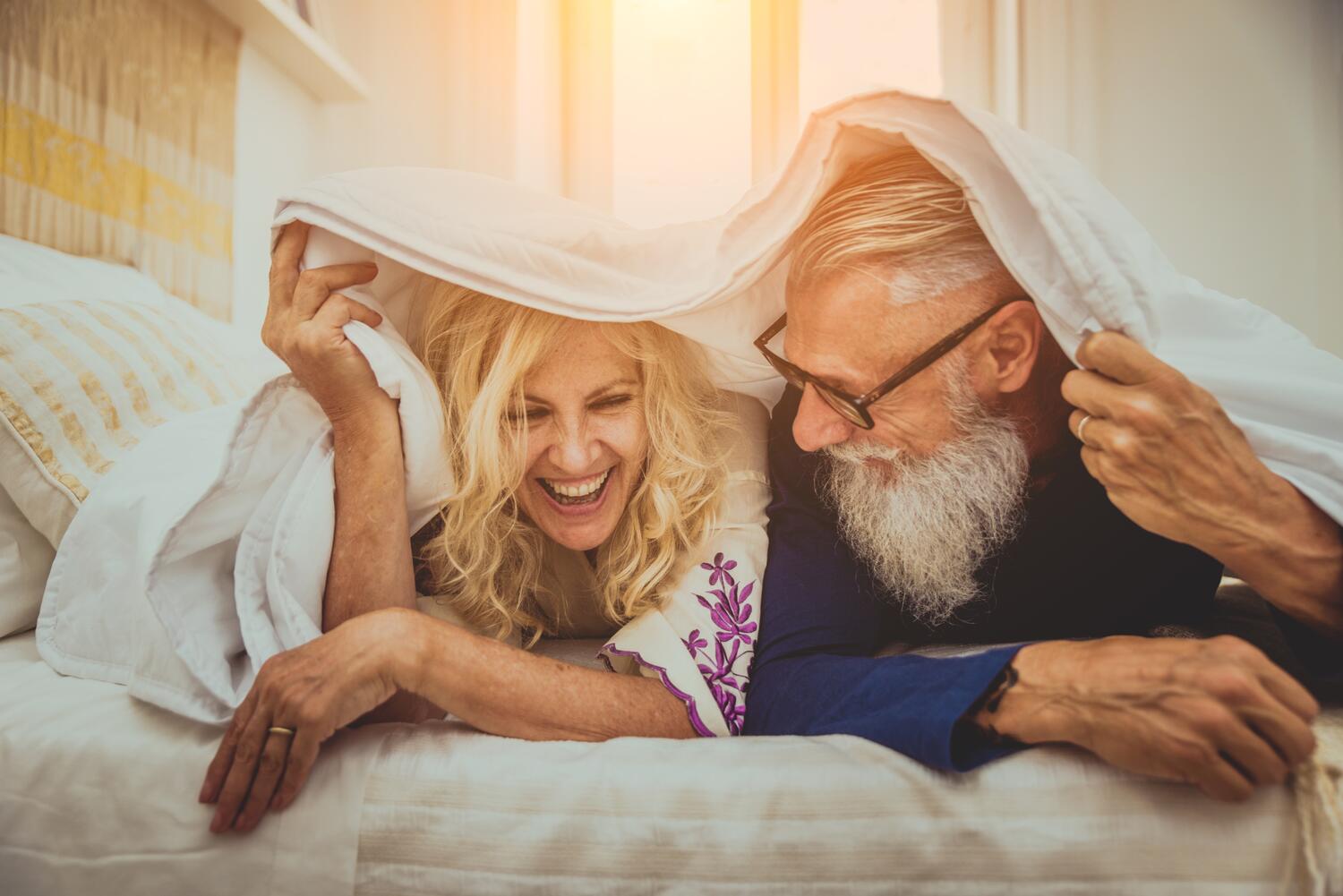 Coppia che si sveglia a letto e sorride