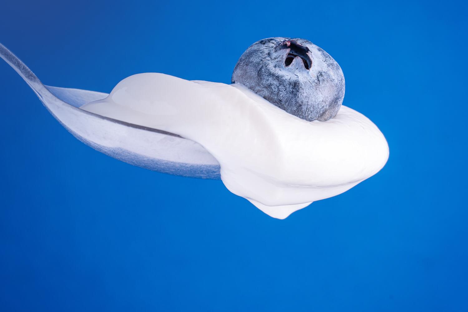 Cucchiaino di yogurt con un mirtillo