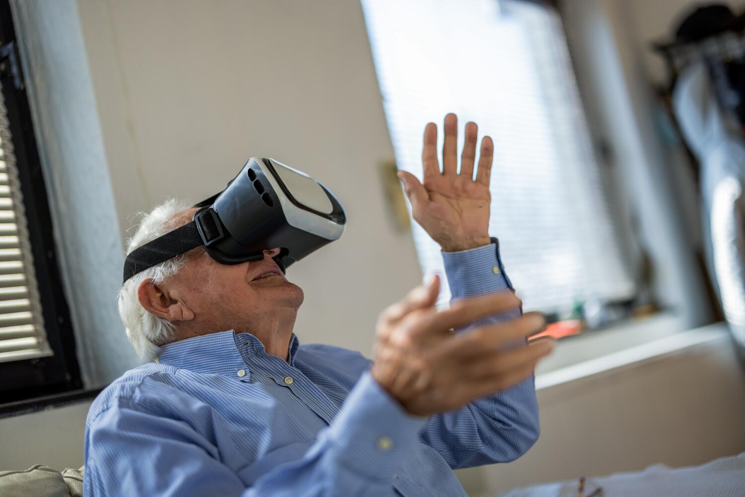 Anziano che usa un visore di realt&agrave; virtuale